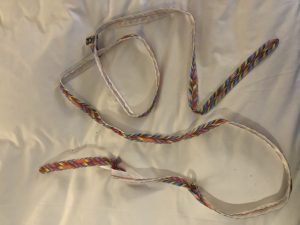 a white fabric with colorful braided straps