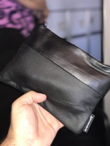 a hand holding a black pouch