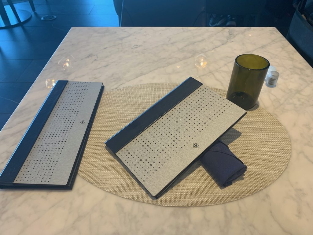 a table with a glass and a table mat