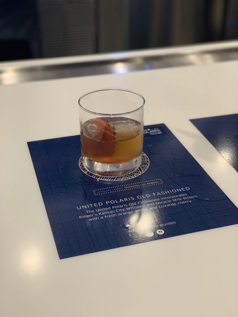 a glass of brown liquid on a blue place mat