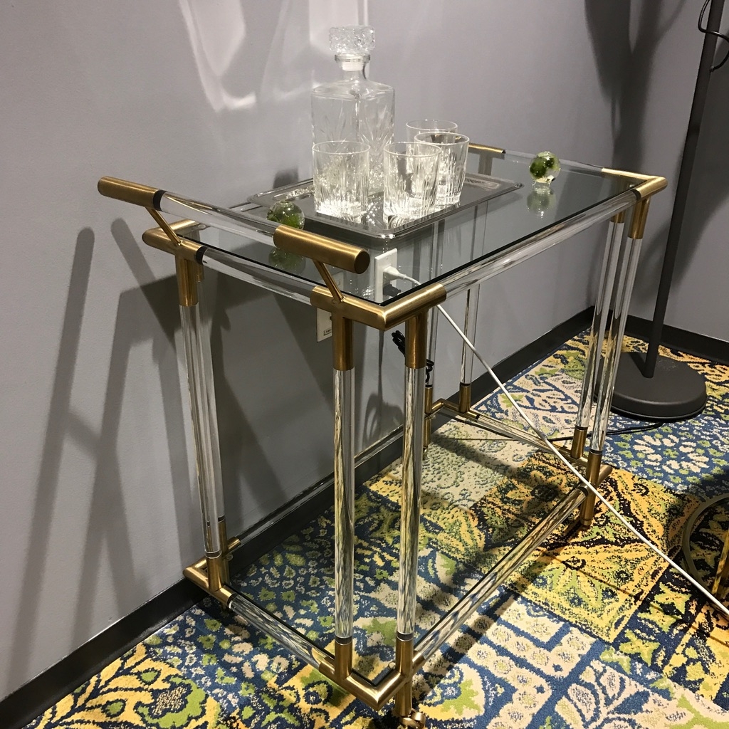 a glass and metal table with a glass decanter on top