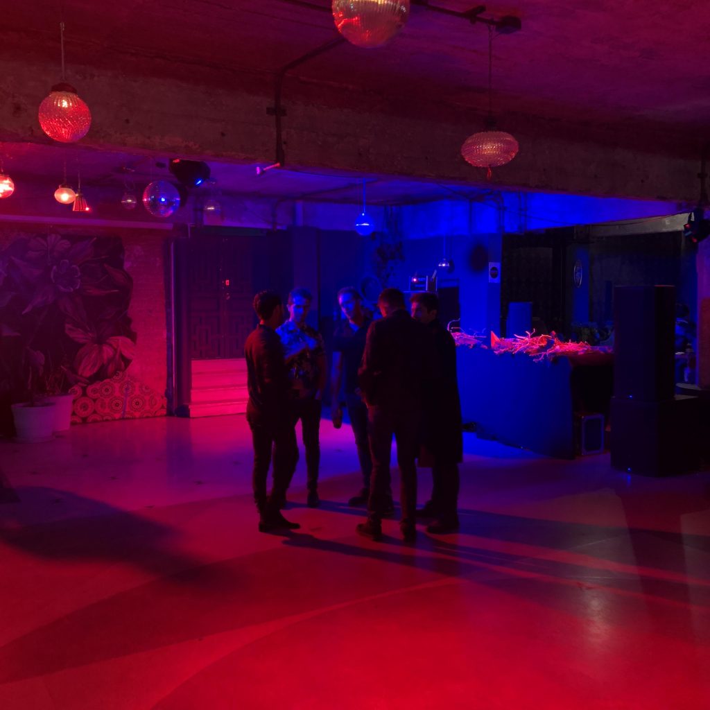 a group of people standing in a room with red lights
