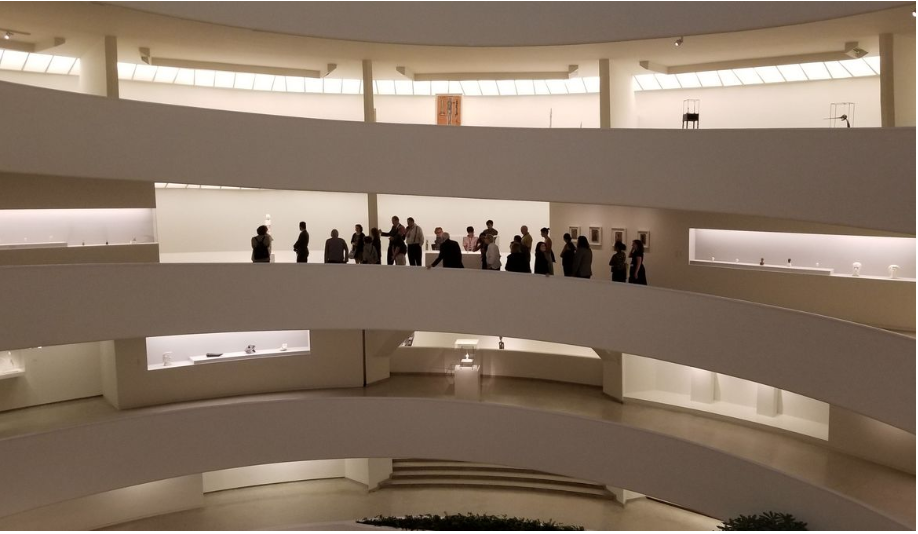 a group of people standing on a curved white building
